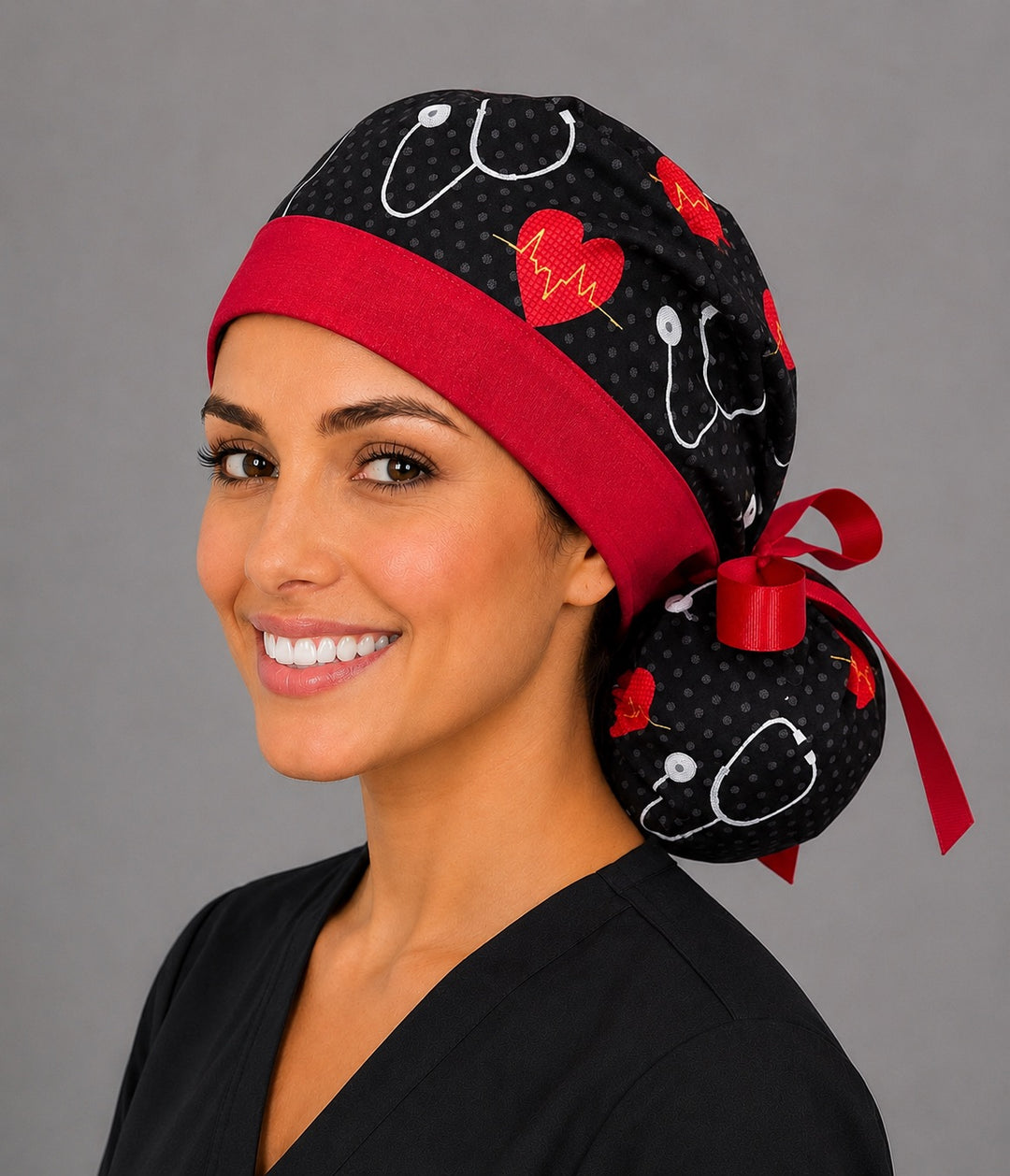 Heartbeat EKG cardiology ponytail nurse cap right three-quarter angle on smiling model showing red hearts, EKG lines, stethoscopes and red band with red ribbon bow