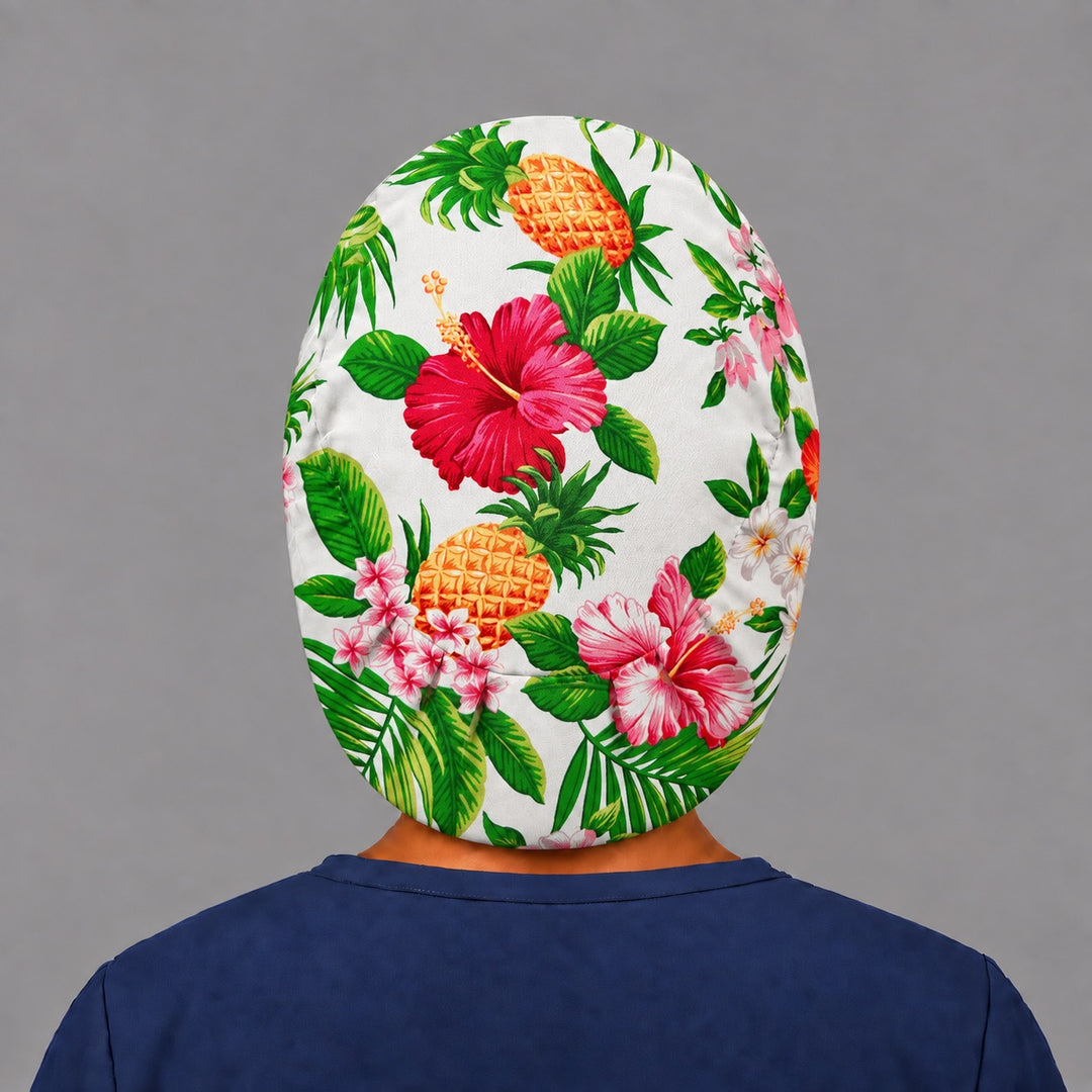 Back view of the hibiscus and pineapple Euro scrub cap — elastic gathered back showing tropical blooms across the white crown