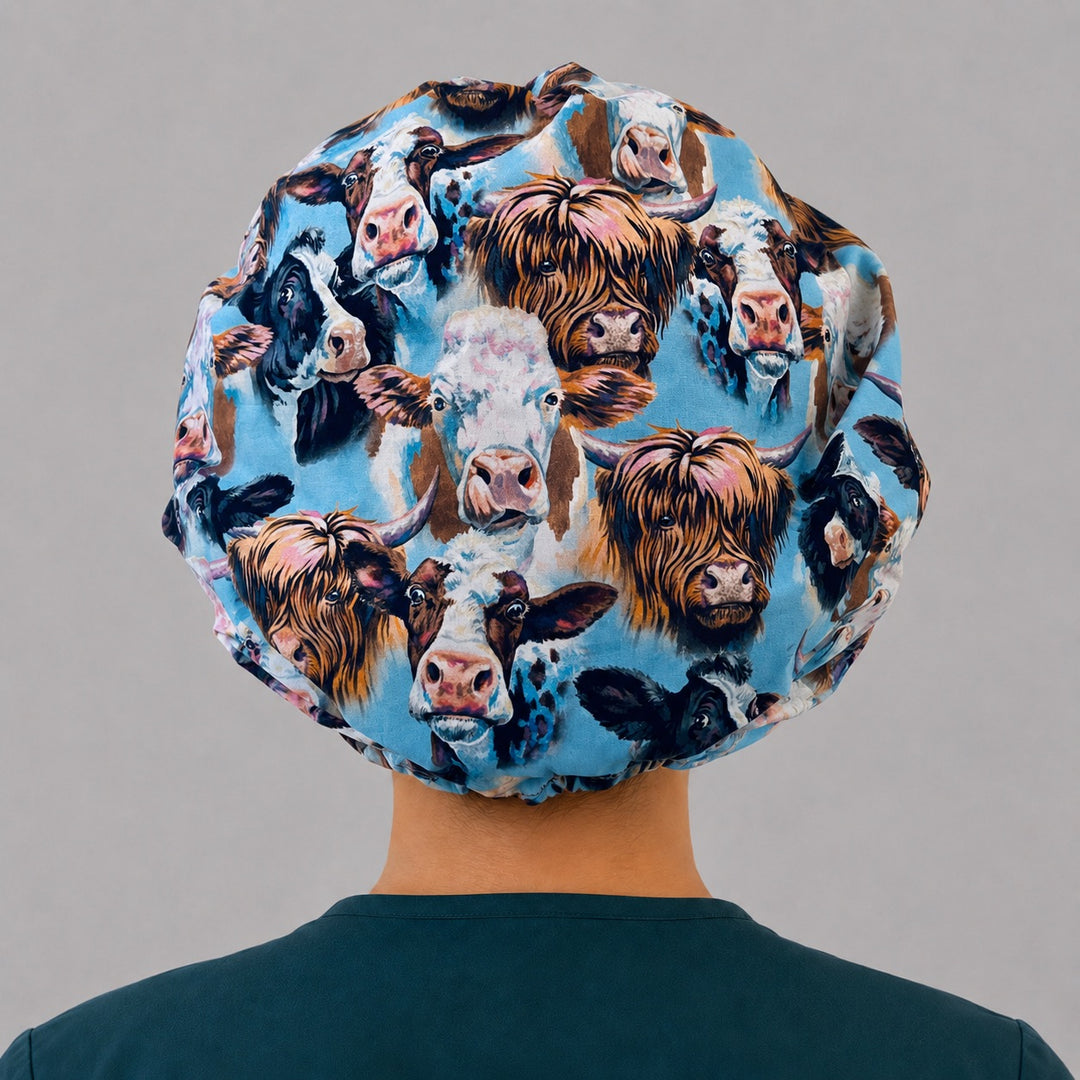 Highland cow farm animals bouffant scrub cap back view showing full print of shaggy Highland cows and dairy cows on sky blue, OR World surgical hat