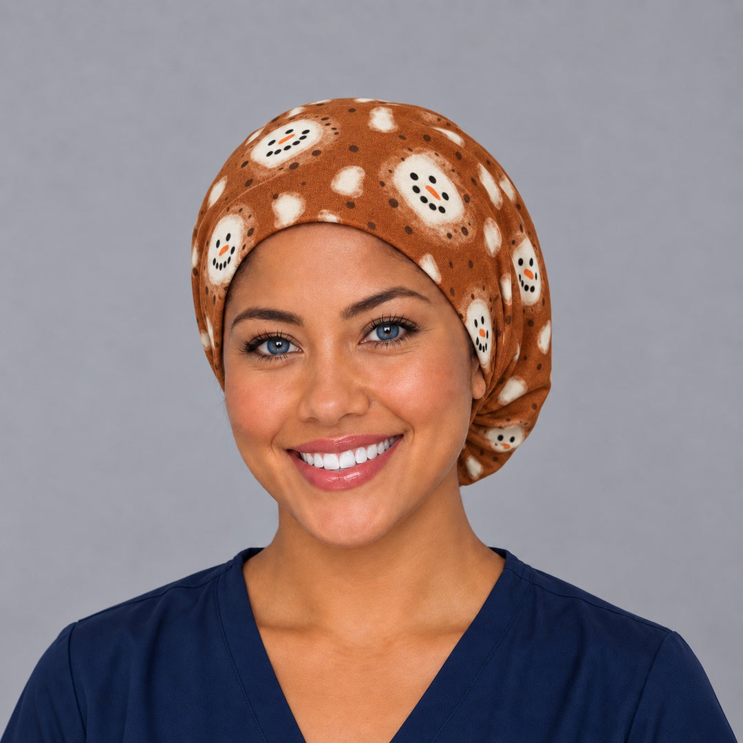 Woman wearing a hot cocoa marshmallow Euro scrub cap, front view — snowman-face marshmallows on cinnamon brown, adjustable winter surgical hat