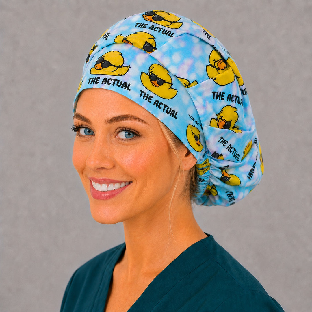 Humor duck bouffant scrub cap in blue tie-dye, left angled view — roomy elastic-back cap that secures long thick or braided hair