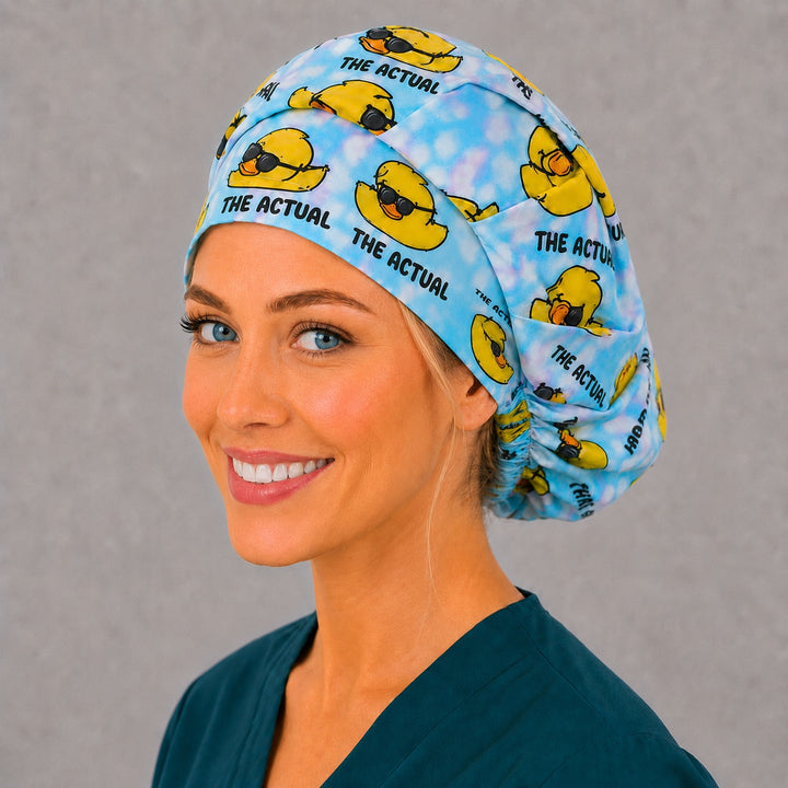 Humor duck bouffant scrub cap in blue tie-dye, left angled view — roomy elastic-back cap that secures long thick or braided hair