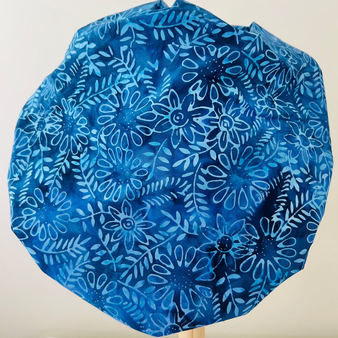 Top view of indigo blue batik floral bouffant scrub cap — handmade-in-USA surgical hat, beautiful gift for nurses &amp; surgeons.
