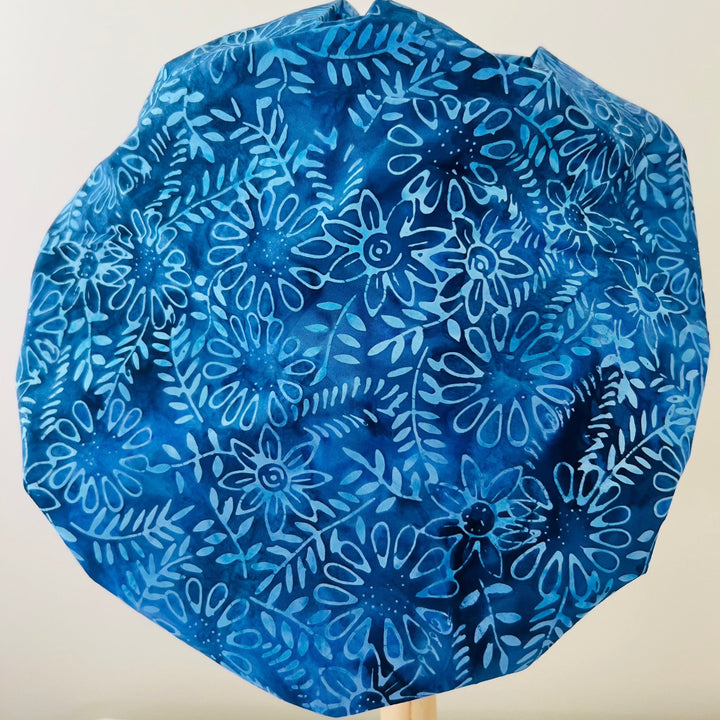 Top view of indigo blue batik floral bouffant scrub cap — handmade-in-USA surgical hat, beautiful gift for nurses &amp; surgeons.