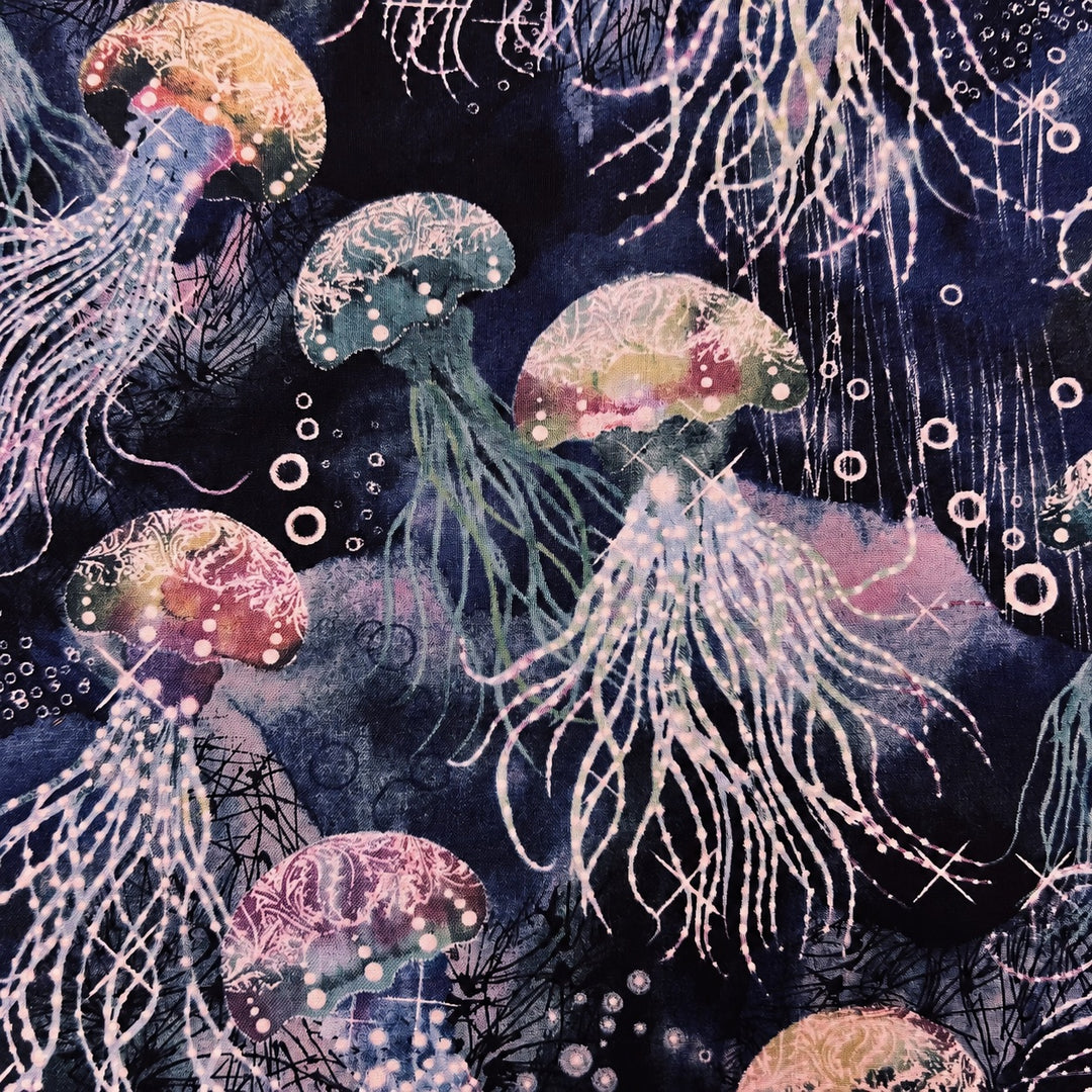 Fabric detail of the jellyfish scrub cap — close-up of the navy batik print with pink and gold jellyfish and bubbles