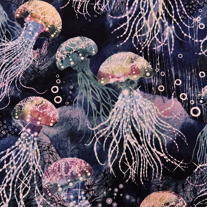 Fabric detail of the jellyfish scrub cap — close-up of the navy batik print with pink and gold jellyfish and bubbles