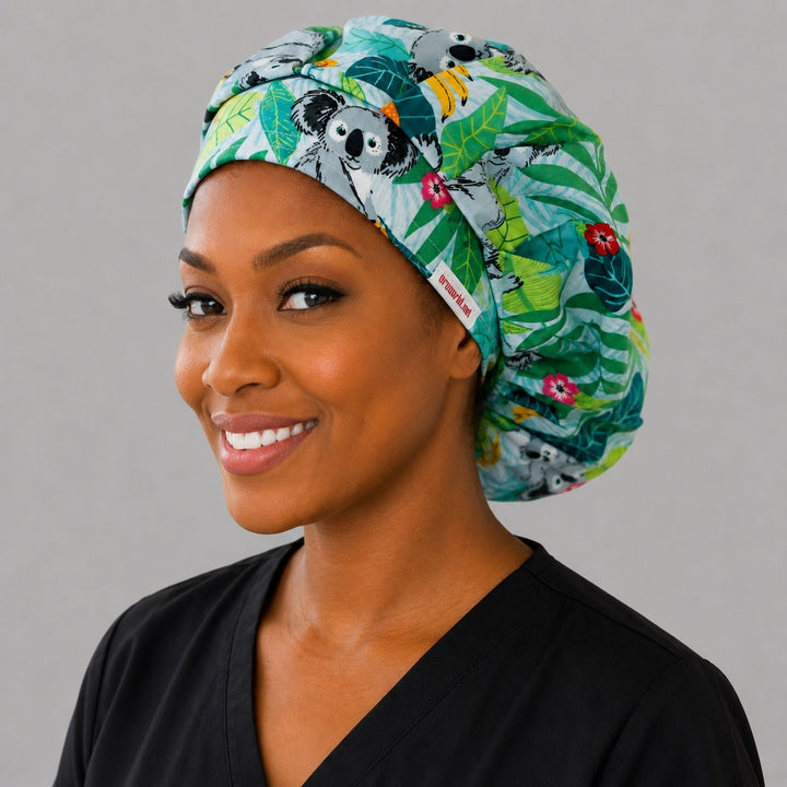 Koala bears tropical leaves bouffant scrub cap right three-quarter angle on smiling model showing koalas and tropical foliage, women&