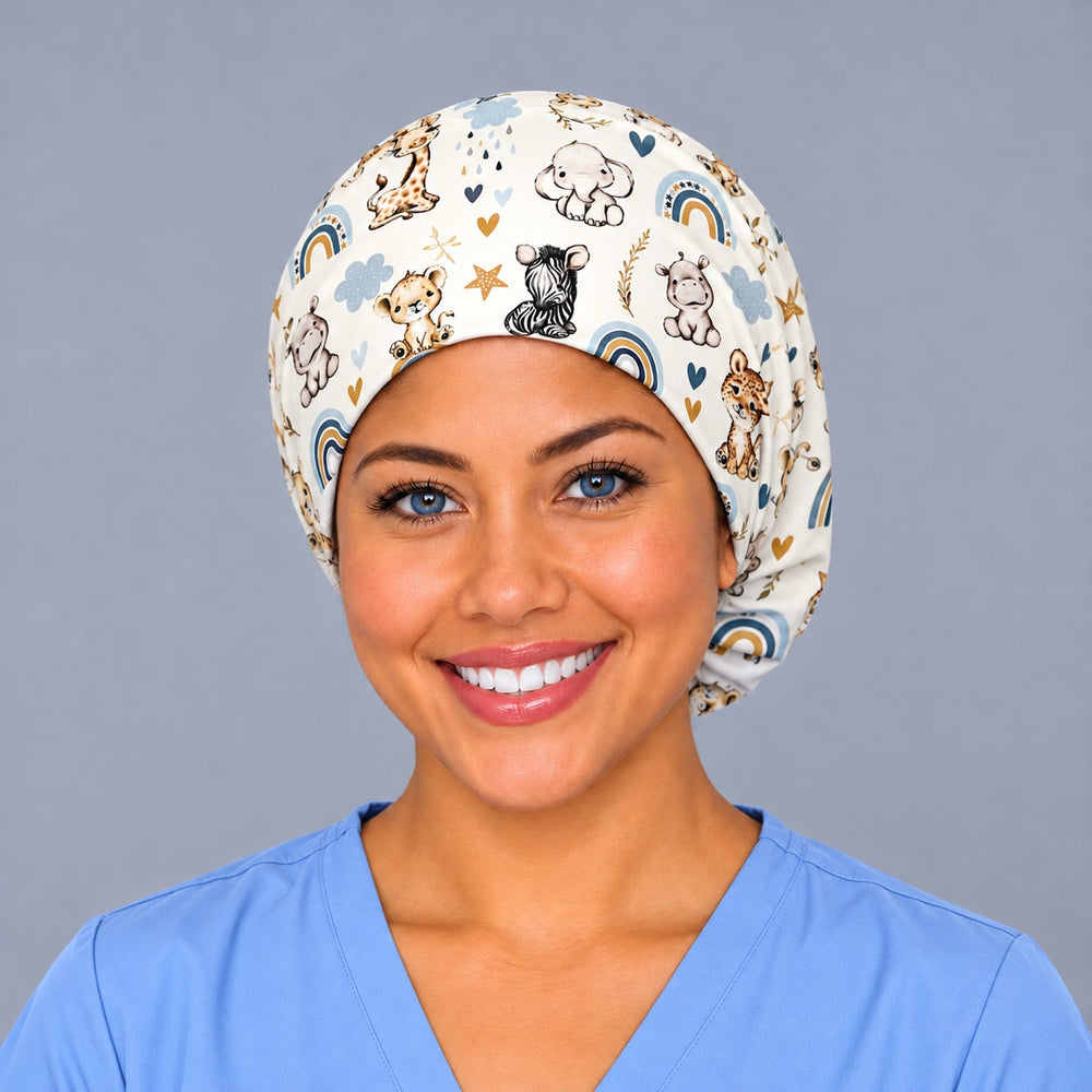 Smiling nurse in ceil blue scrubs wearing a labor and delivery euro scrub cap, front view of baby safari animals and boho rainbows on cream across the forehead