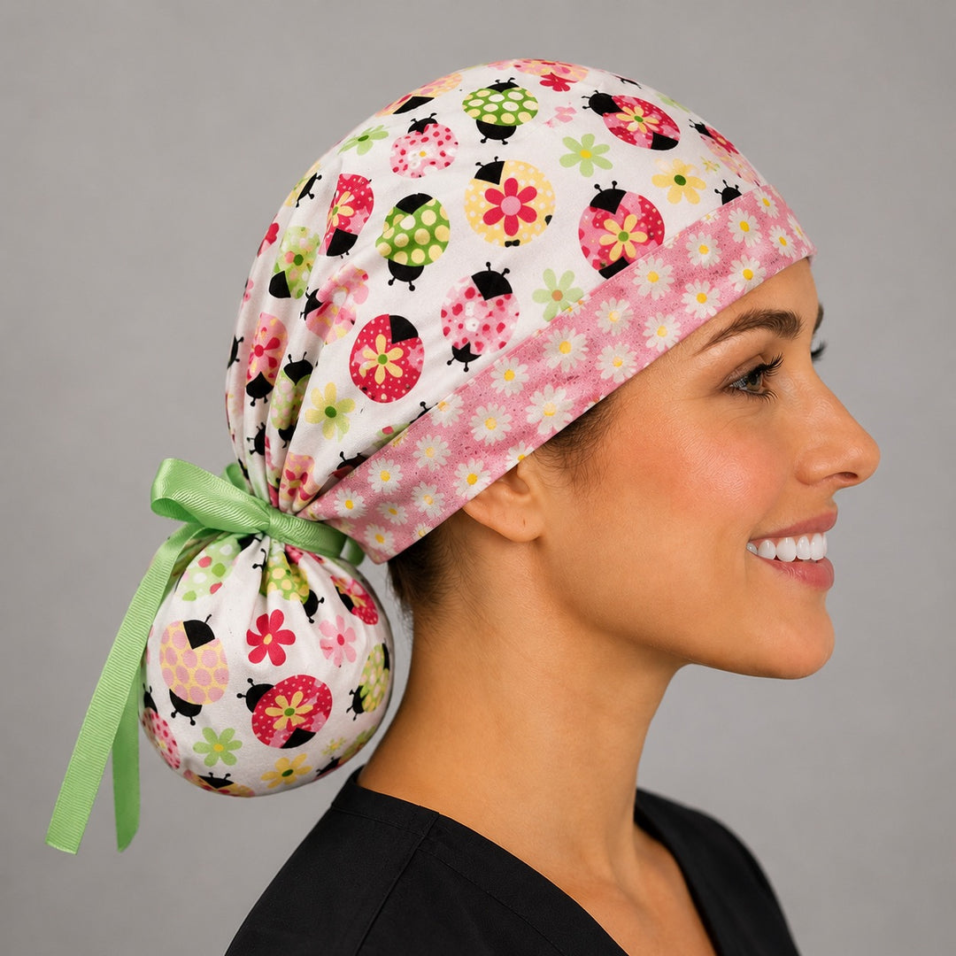 Ladybug daisy ponytail surgical cap left side profile showing gathered ponytail pouch of floral ladybugs, daisies and green grosgrain ribbon bow