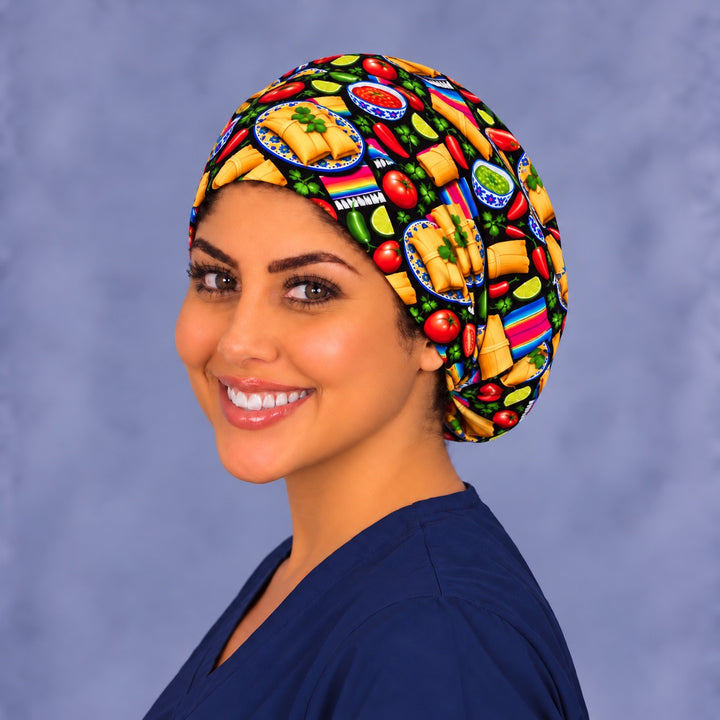 Three-quarter angle of a smiling healthcare worker in a tamale scrub hat, with tamales on blue Talavera plates and lime wedges shown at true print scale