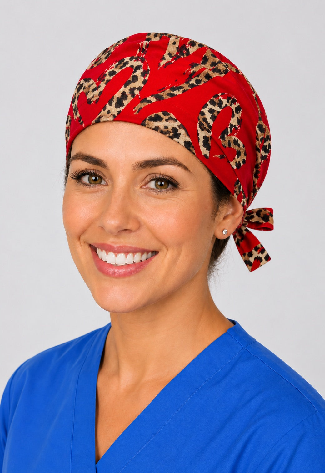Nurse wearing red leopard heart tie back scrub cap, cheetah print hearts surgical hat with side tie by OR World