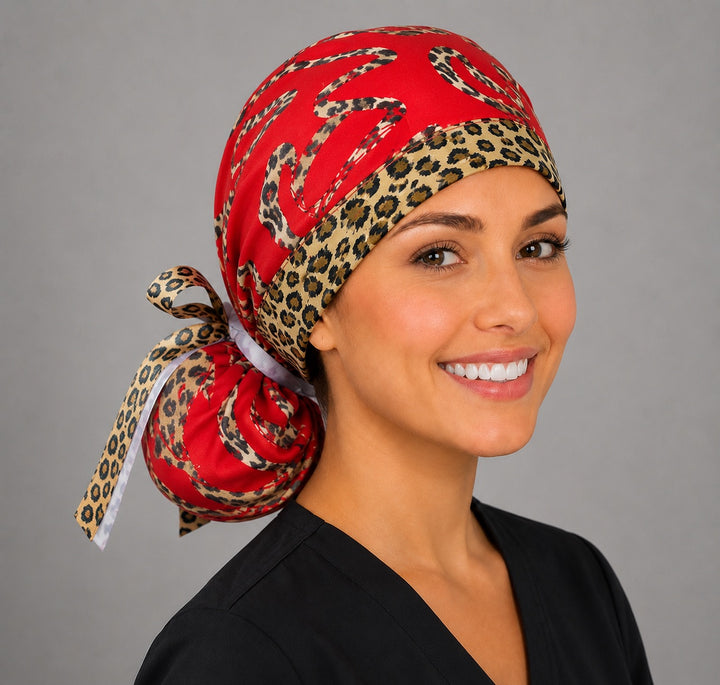 Leopard print hearts ponytail surgical cap right three-quarter angle showing gathered ponytail pouch of leopard hearts on red with animal-print ribbon bow