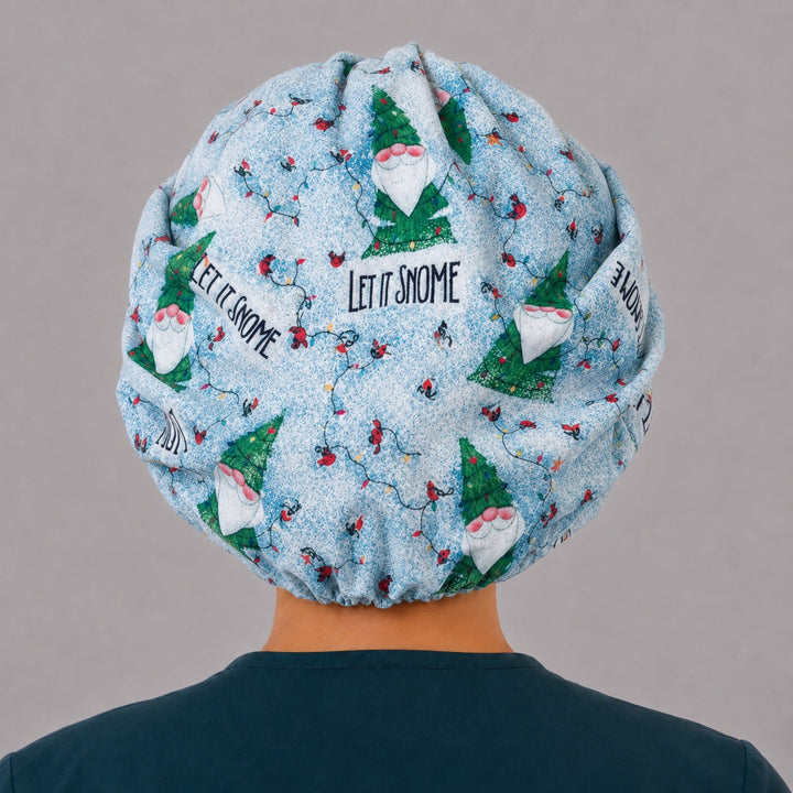 Back view of the Let It Snome bouffant scrub cap — full gathered fit showing tree gnomes, cardinals and string lights on sky blue