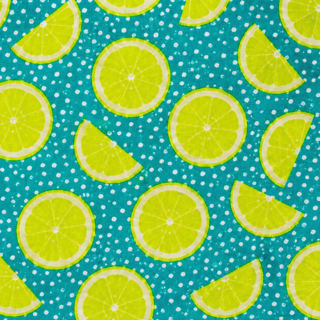Lime citrus fabric print swatch — bright lemon lime slices on a teal polka dot background for OR World handmade Euro scrub caps.