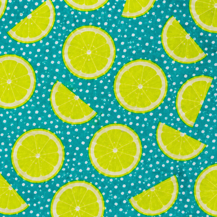 Lime citrus fabric print swatch — bright lemon lime slices on a teal polka dot background for OR World handmade Euro scrub caps.