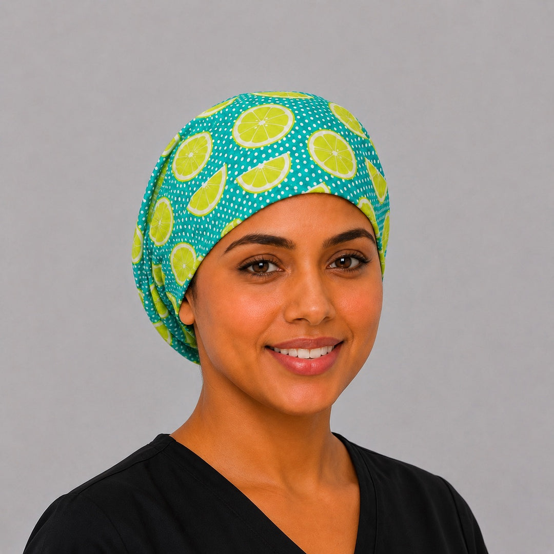 Lime citrus Euro scrub cap with bright lime slices on teal polka dots, front view on a model — handmade-in-USA surgical hat for women from OR World.