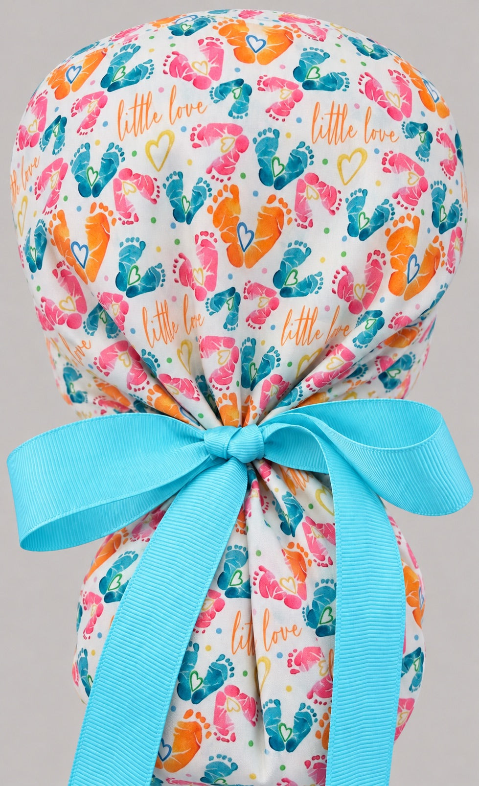 Back view of the Little Love ponytail cap, showing the gathered crown above long aqua grosgrain ribbon tails tied in a wide bow