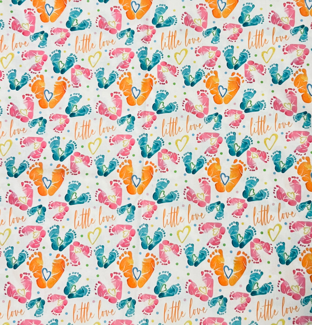 Fabric detail of the Little Love print used on the ponytail cap, with watercolor baby feet, heart accents and orange script on white cotton