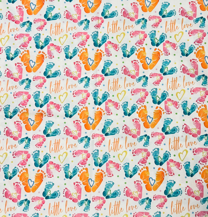 Fabric detail of the Little Love print used on the ponytail cap, with watercolor baby feet, heart accents and orange script on white cotton