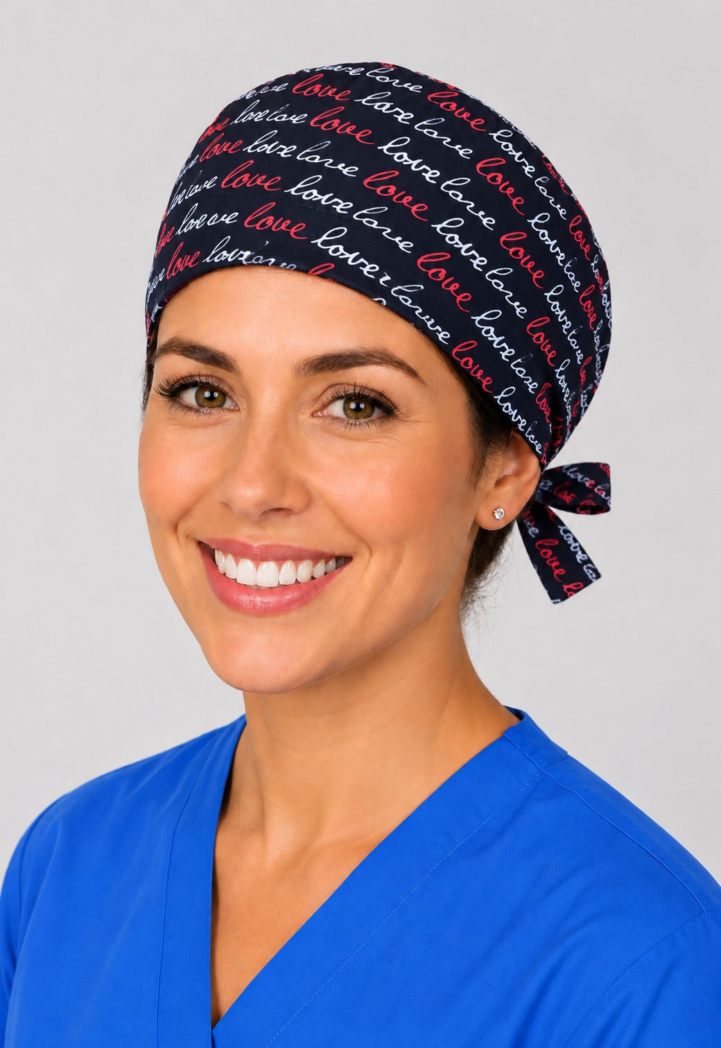 Nurse wearing love script tie back scrub cap, black surgical hat with red and white cursive lettering by OR World