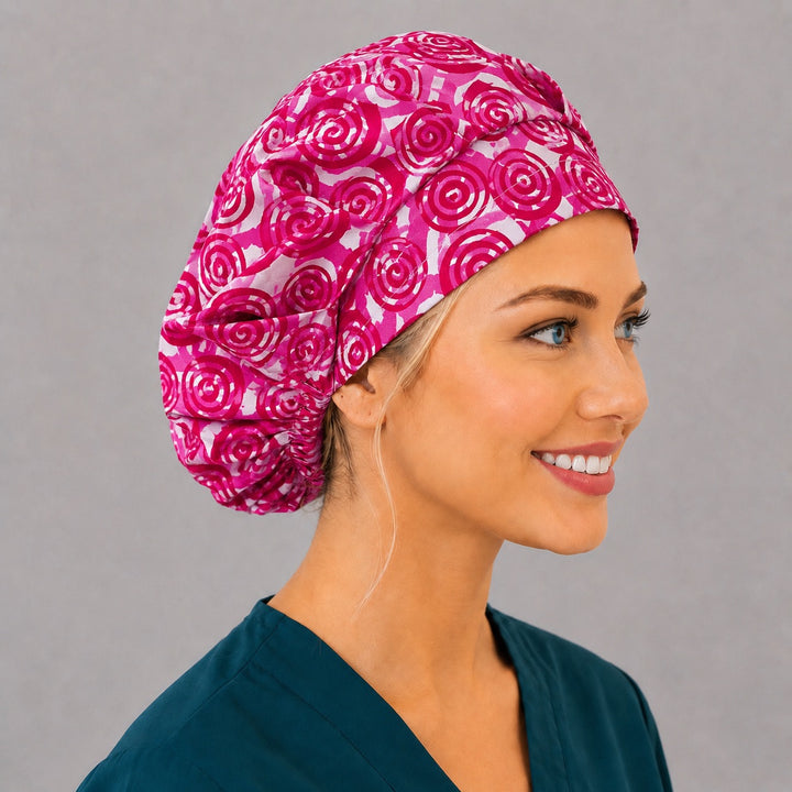 Magenta swirl bouffant cap for women, right angled smiling view — handmade Valentine spiral surgical cap, USA made