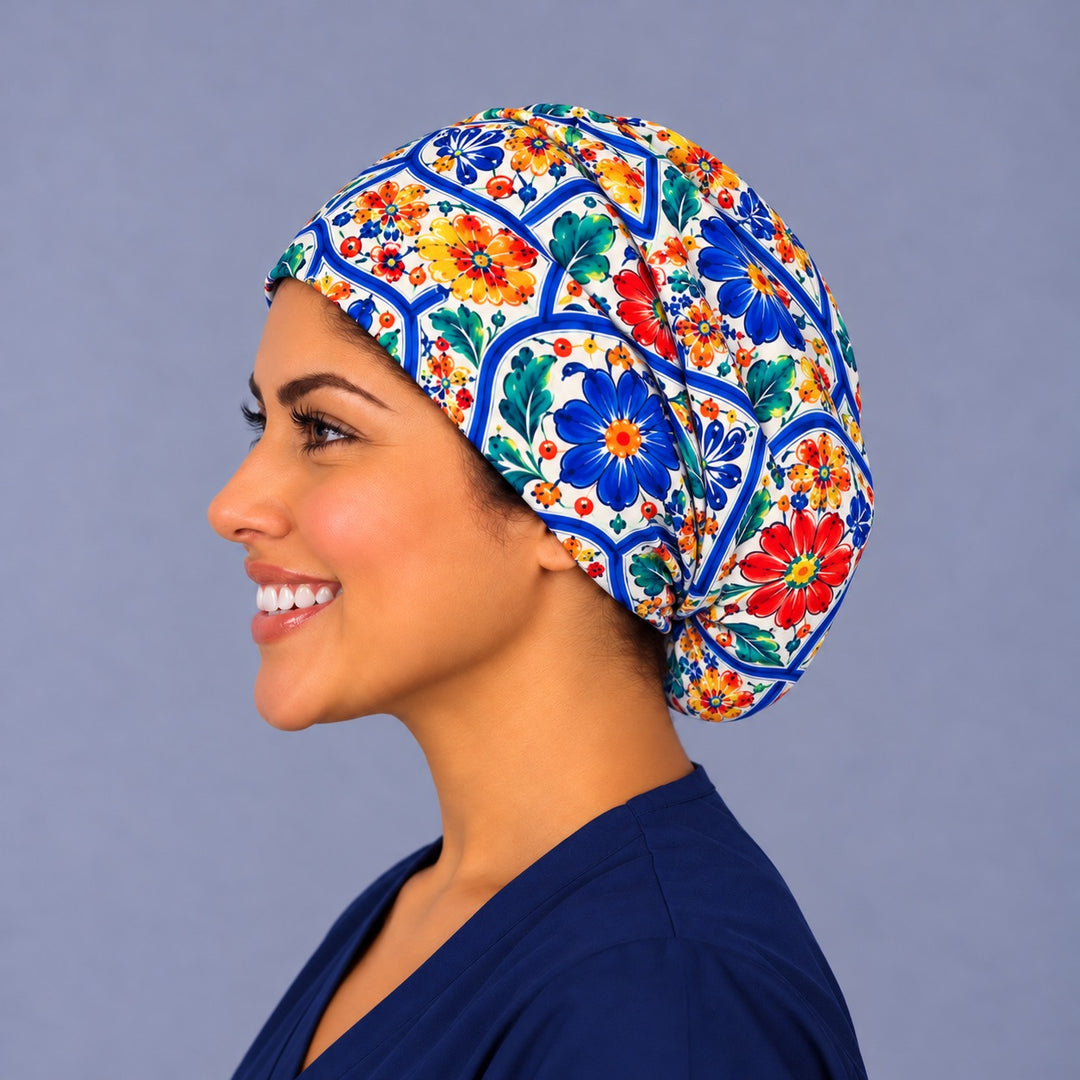 Left profile of a majolica floral Euro scrub cap in 100% cotton, roomy enough at the back for short or long hair, with blue and red flowers wrapping the side