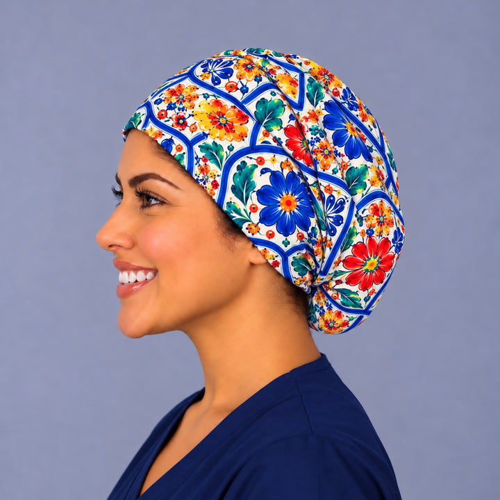 Left profile of a majolica floral Euro scrub cap in 100% cotton, roomy enough at the back for short or long hair, with blue and red flowers wrapping the side