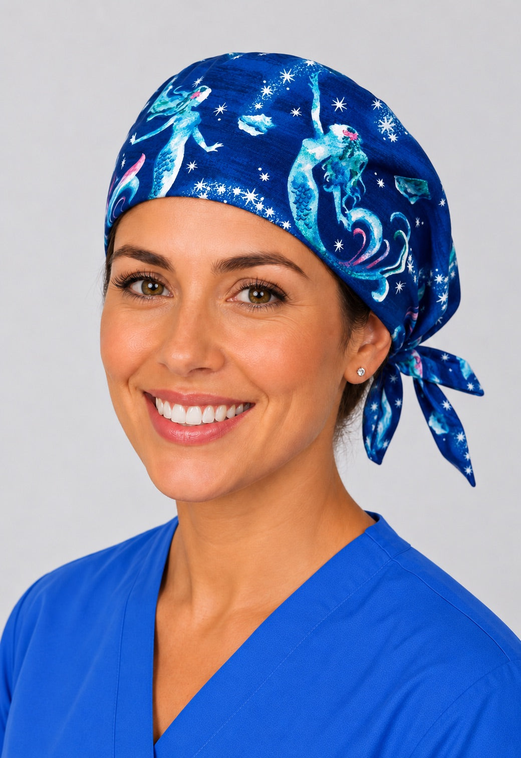 Nurse wearing mermaid galaxy tie back scrub cap, navy ocean and stars surgical hat with side tie by OR World