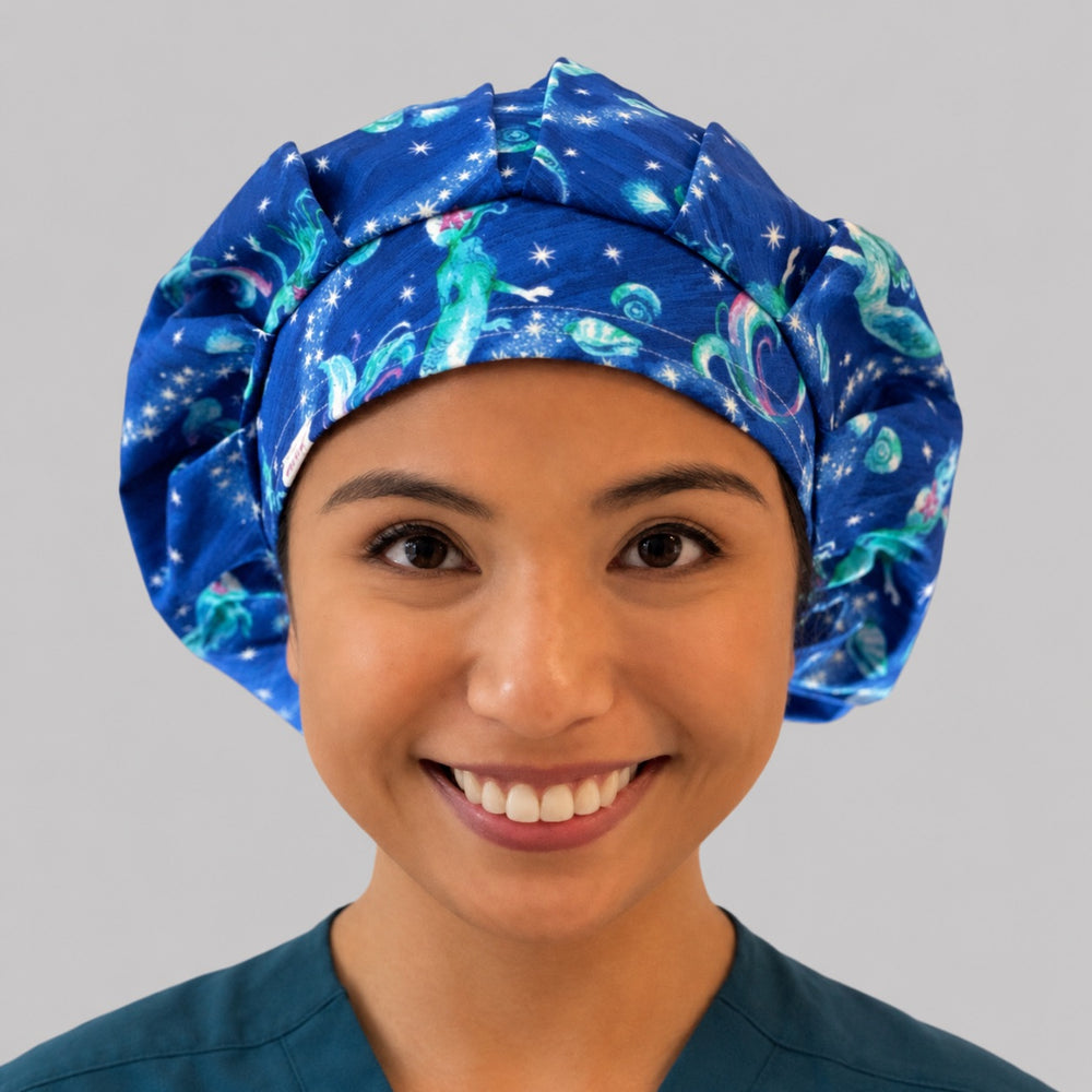 Mermaid ocean galaxy bouffant scrub cap for women, front view, glowing mermaids and stars on deep blue starry sea, handmade surgical hat by OR World