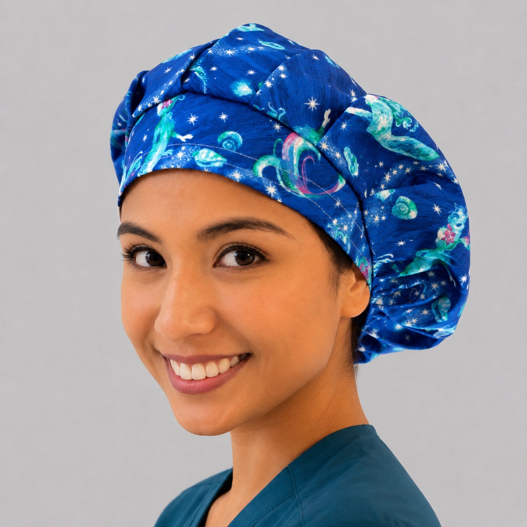 Mermaid ocean galaxy bouffant scrub cap left three-quarter angle on smiling model, glowing mermaids and stars on starry blue sea, women's surgical hat OR World