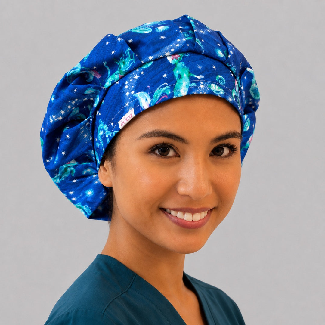 Mermaid ocean galaxy bouffant surgical cap right three-quarter angle on smiling model, glowing mermaids and stars on blue, OR World nurse hat