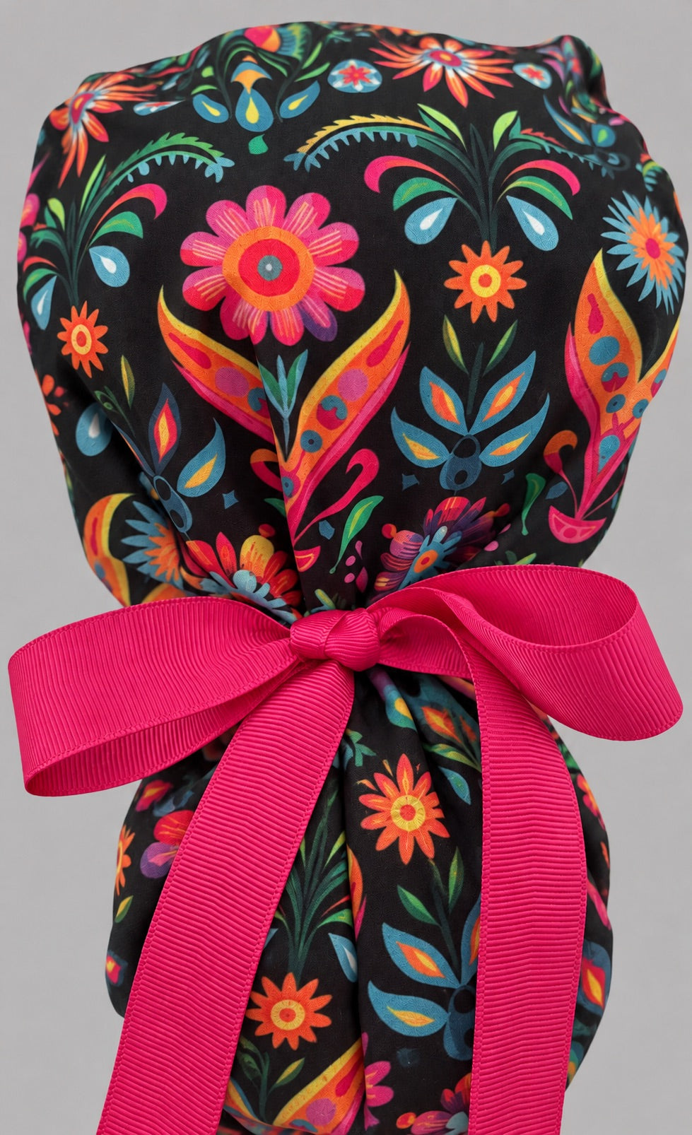 Mexican embroidery floral ponytail cap, left angled smiling view — handmade fiesta print surgical cap, USA made