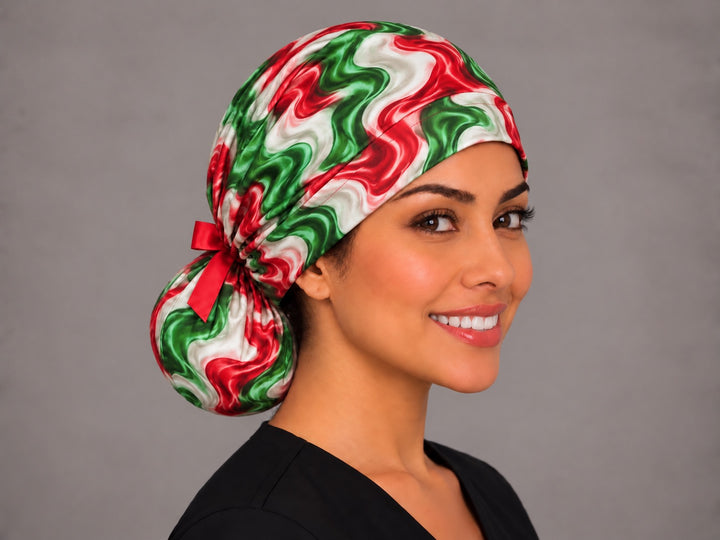 Right three-quarter angle of a Mexican flag colors ponytail OR cap, with a short red ribbon bow cinched where the band meets the pouch