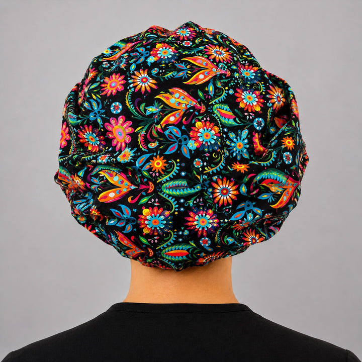 Back view of Mexican floral bouffant scrub cap for women, black background colorful fiesta adjustable surgical hat