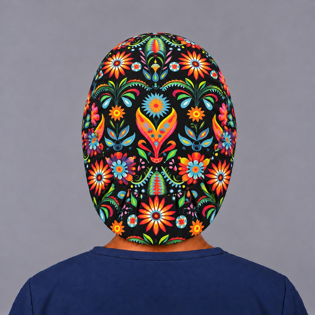Back view of the Mexican floral euro cap, showing the oval crown panel with a centered heart motif and the gathered elastic toggle closure at the nape
