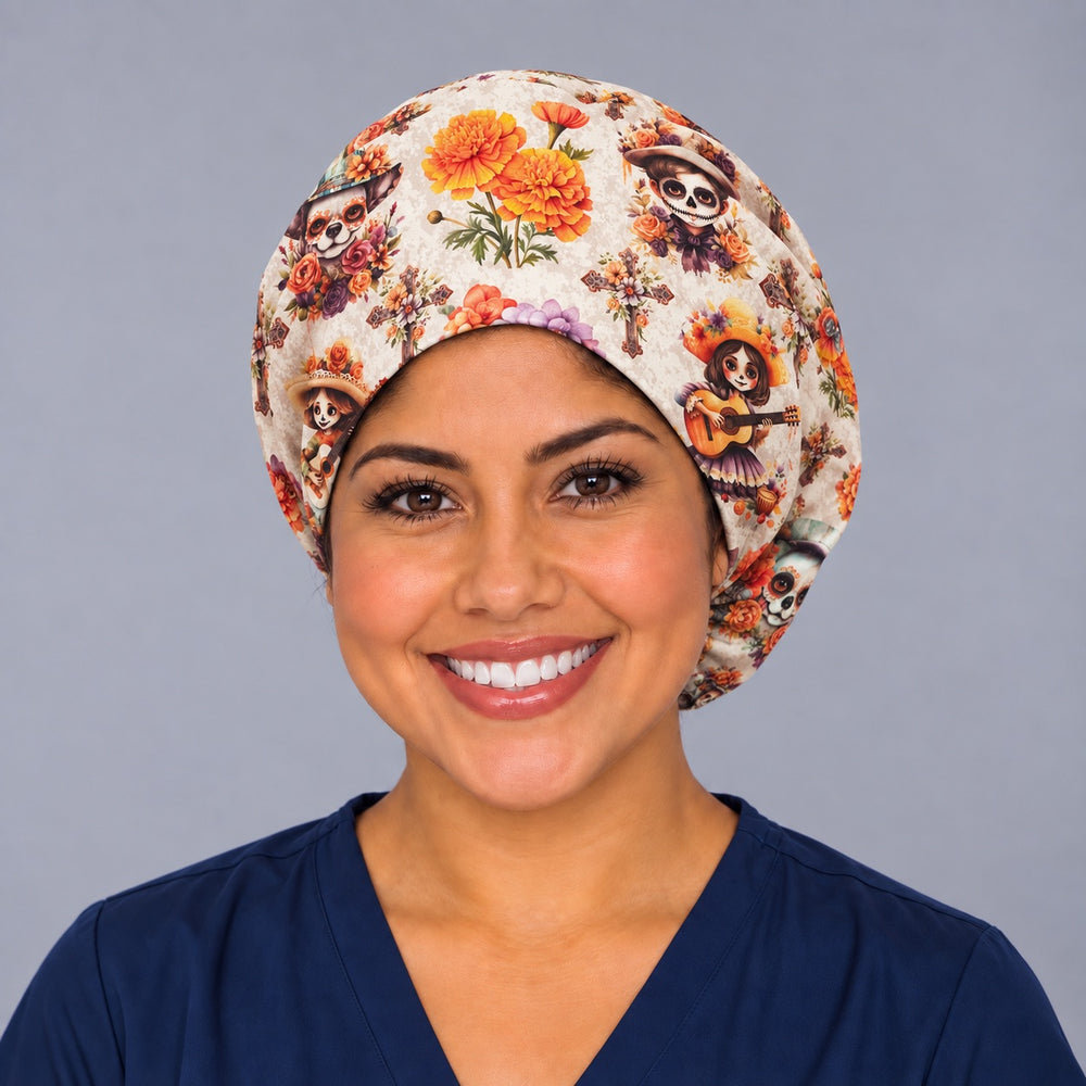 Nurse wearing the cream Mexican marigold Euro scrub cap, front view, orange cempasúchil flowers and Día de los Muertos calaveras on a handmade surgical hat for women