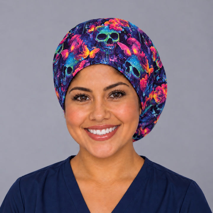 Nurse wearing a Mexican neon skull and butterfly Euro surgical hat, front view, bright marigold and violet print