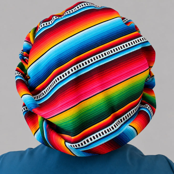 Back of the Mexican serape bouffant cap, full coverage over a bun with rainbow sarape stripes and black and white ladder trim