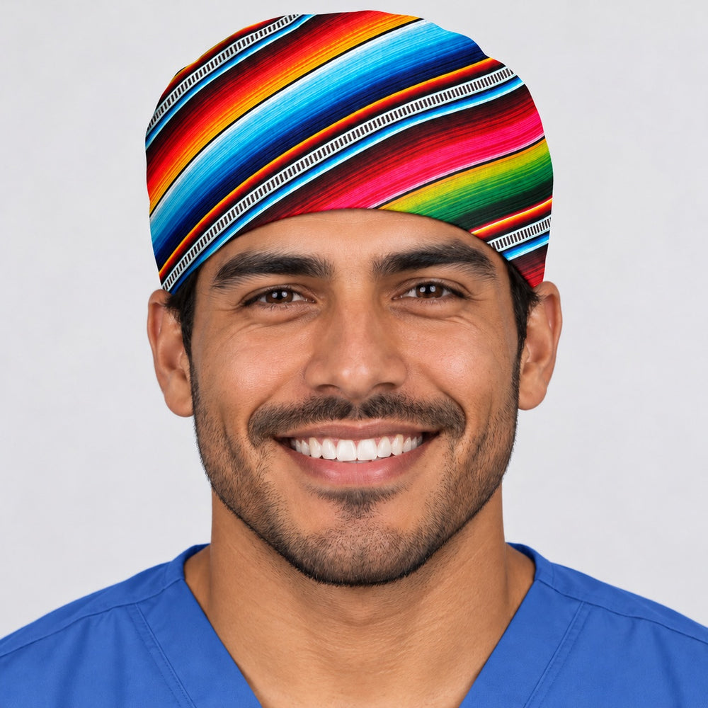 Smiling surgeon in royal blue scrubs wearing a Mexican serape tie-back scrub cap, front view of the snug forehead fit with turquoise, red and green stripes sweeping across the crown