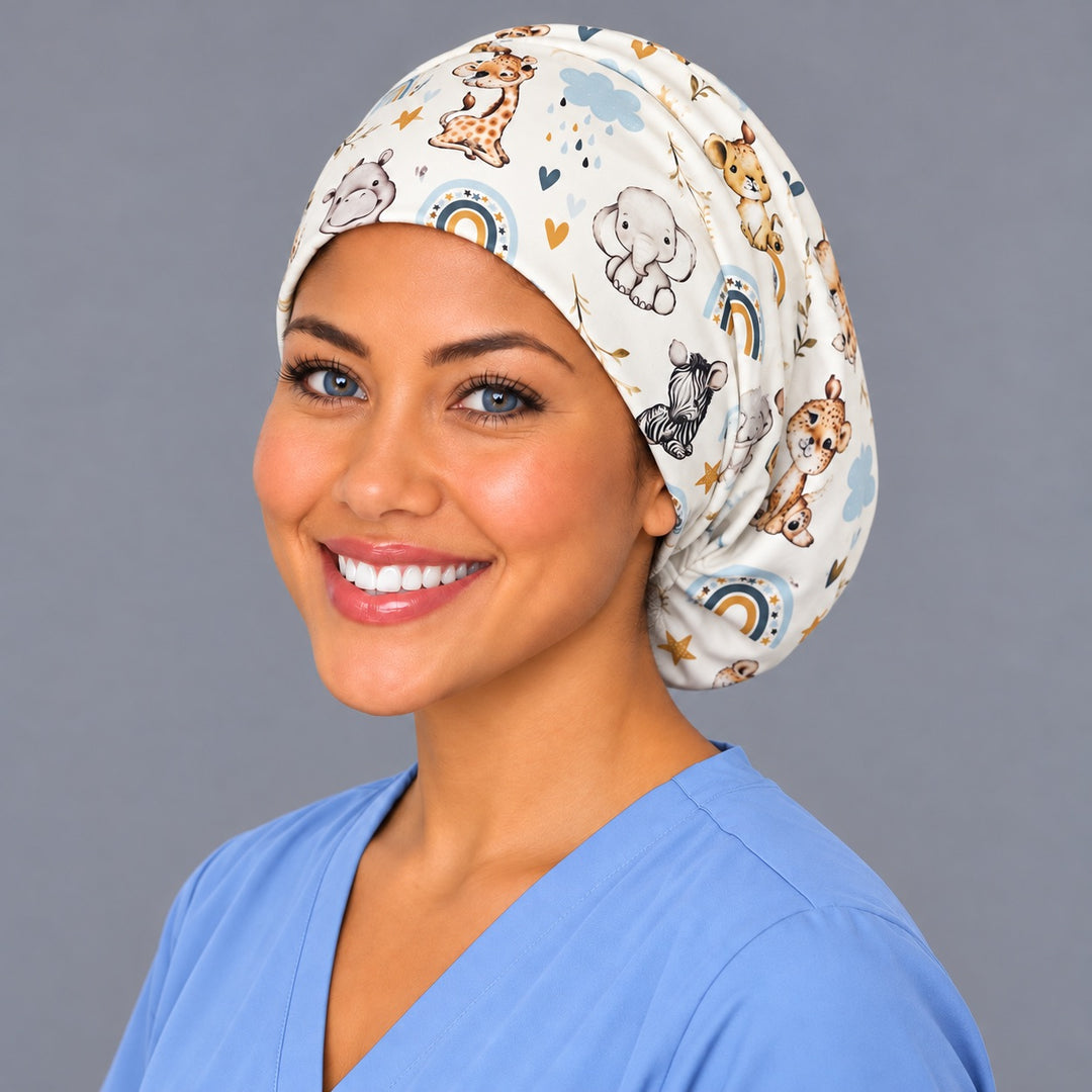 Left three-quarter angle of a smiling midwife in a nursery animal scrub cap, with a baby hippo and lion cub at true print scale along the band