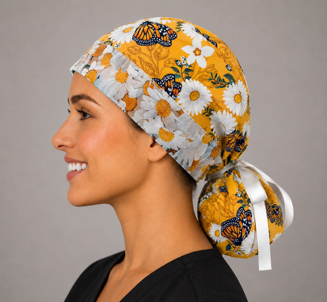 Monarch butterfly daisy ponytail surgical cap left side profile showing gathered ponytail pouch of monarchs and daisies on golden yellow with white ribbon tie