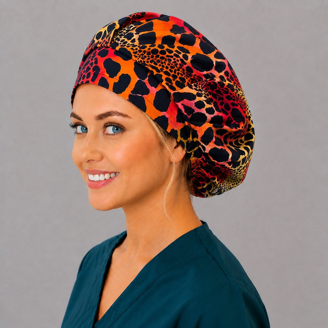 Woman wearing a neon cheetah print bouffant scrub cap, front view — red, orange and yellow leopard spots on black, adjustable women's surgical hat