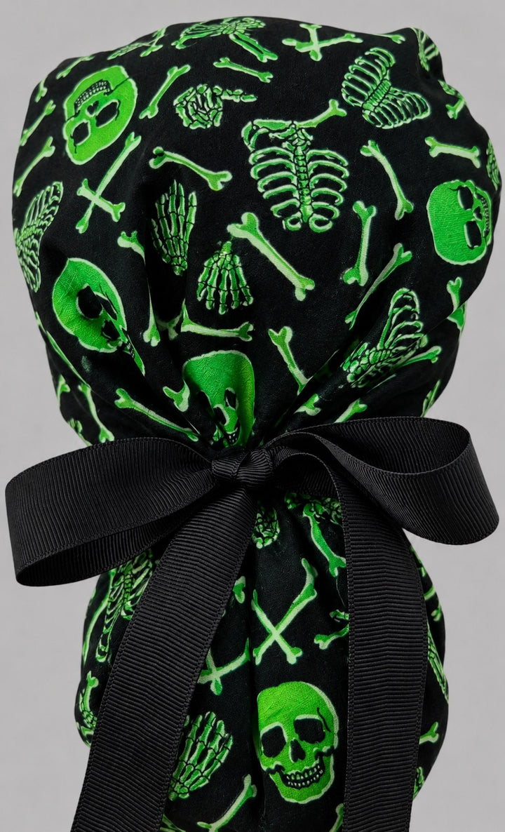 Neon green skeleton ponytail scrub cap back view on mannequin showing gathered pouch of green skulls and bones and black ribbon bow