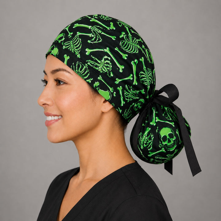 Neon green skeleton ponytail scrub cap left side profile with full ponytail pouch of glowing green skulls and bones and black tie-back