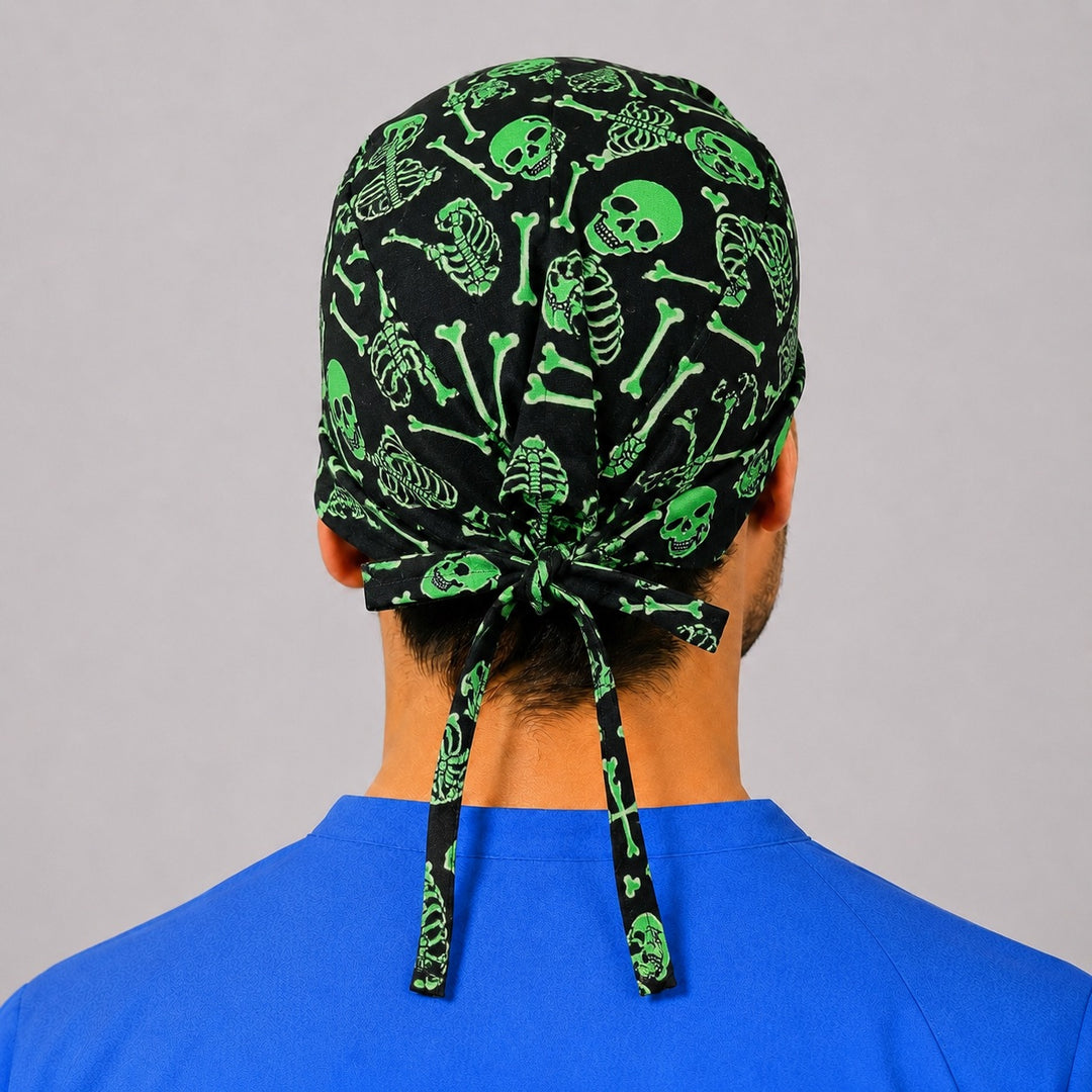 Neon green skeleton scrub cap front view on a man — skulls and bones on black, cotton tie-back Halloween surgical cap for nurses