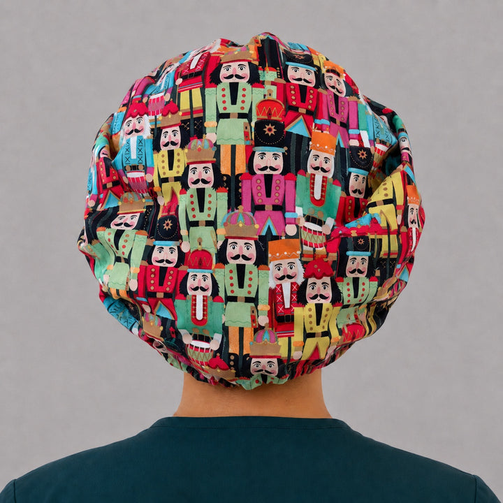 Back view of the nutcracker bouffant scrub cap — full gathered fit showing rows of painted toy soldiers with crowns and drums
