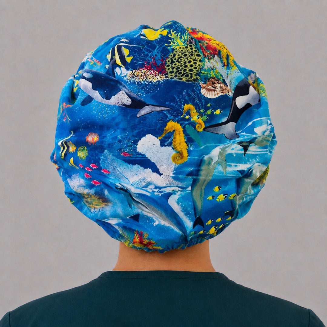 Back view of the ocean life bouffant scrub cap — full gathered fit showing orcas, seahorses, sharks and coral across the blue crown