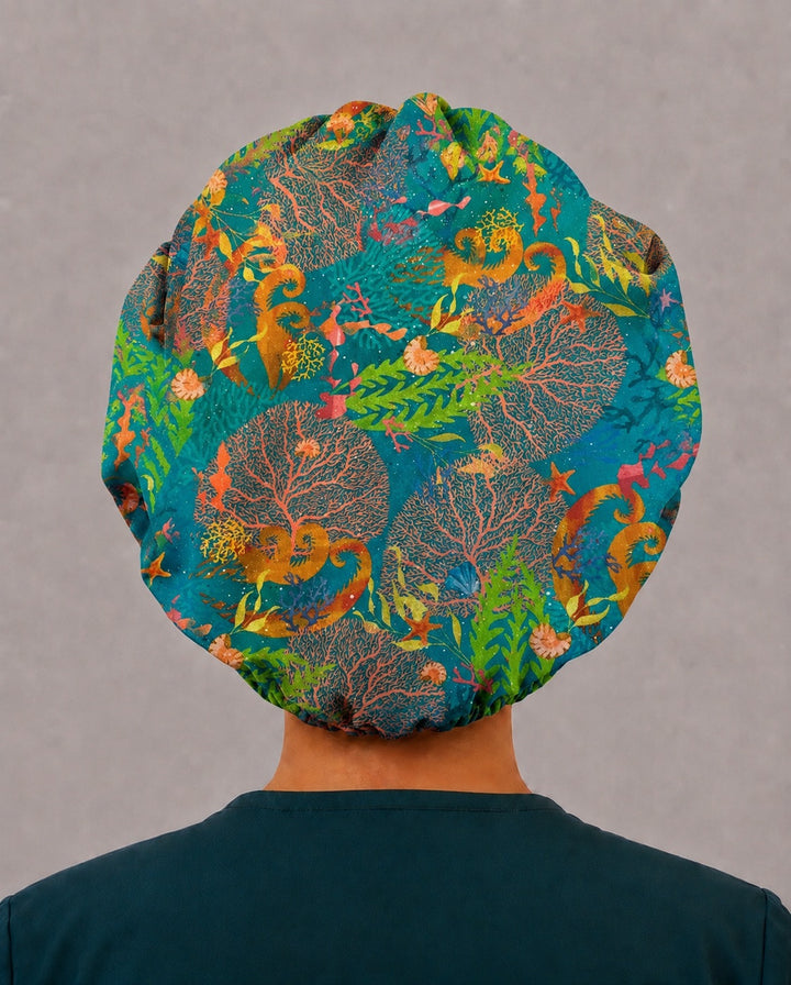 Back view of the ocean reef bouffant scrub cap — full gathered coverage showing seahorses, sea fans and nautilus shells across the crown