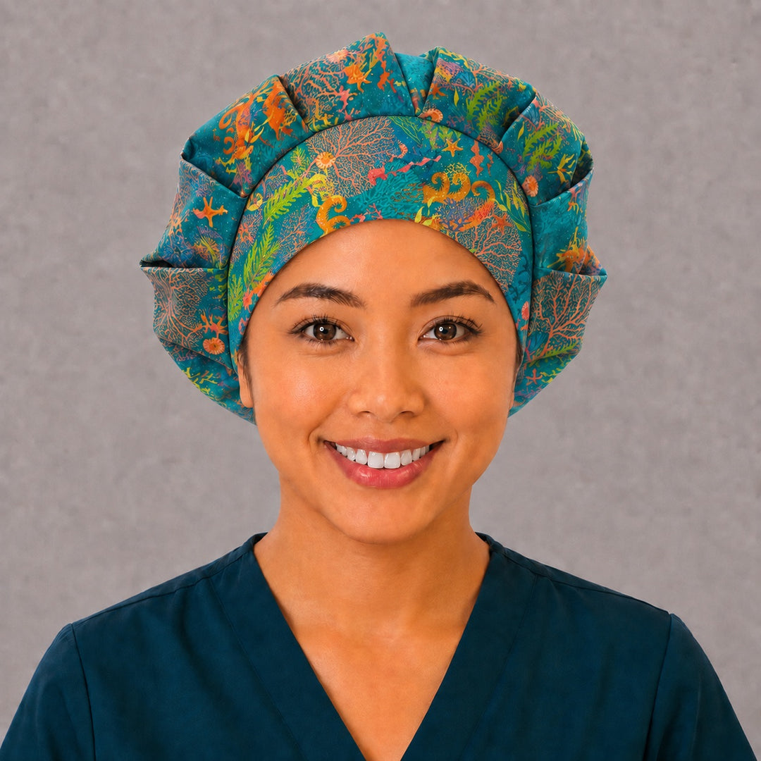Woman wearing an ocean reef seahorse bouffant scrub cap, front view — golden seahorses and coral on teal, adjustable women&