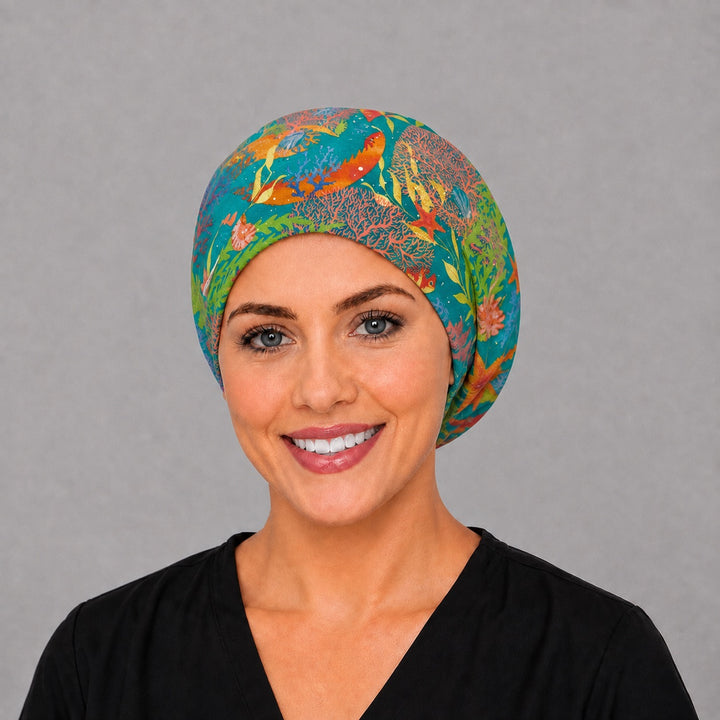 Woman wearing an ocean reef seahorse Euro scrub cap, front view — golden seahorses and coral on teal, adjustable surgical hat for nurses